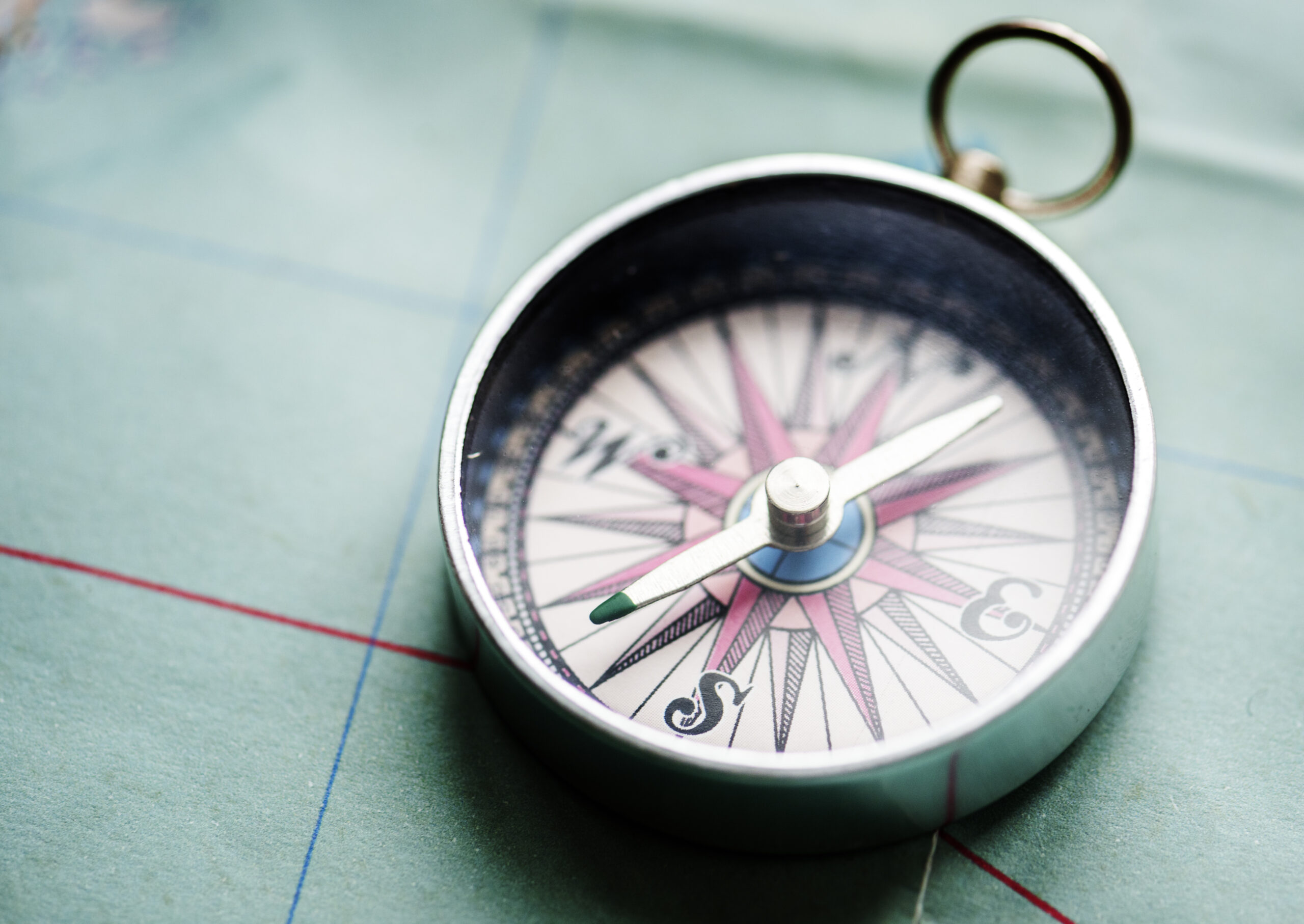 Closeup of metallic compass on the map journey planning